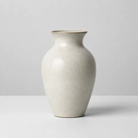 Minh họa cho “Định danh vật thể”: a single ceramic vase centered on a plain table.