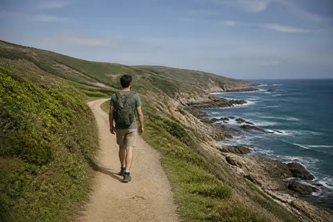 Minh họa cho “đường mòn ven biển”: A hiker along a coastal path.